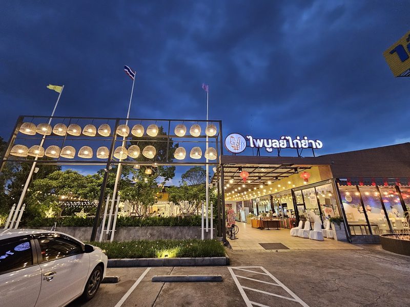 หน้าร้านยามค่ำ โครงโคมไฟสานเปิดไฟสว่าง และป้ายชื่อร้าน